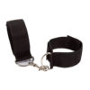 "Adjustable black ankle restraints with a metal connector clip, worn around ankles, paired with black high heels."