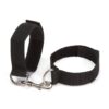 "Adjustable black wrist restraints with a metal connector clip, shown on hands with manicured nails."