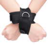 "Adjustable adhesive hand restraints made from durable black fabric with a metal ring, designed for secure and comfortable use during intimate moments."