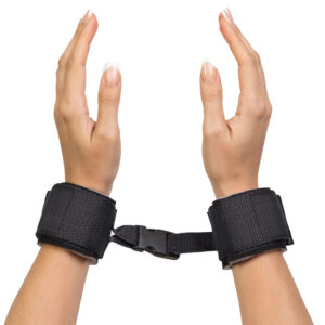 "Black adjustable wrist restraints with a secure buckle connection, offering a comfortable and reliable fit for various uses."